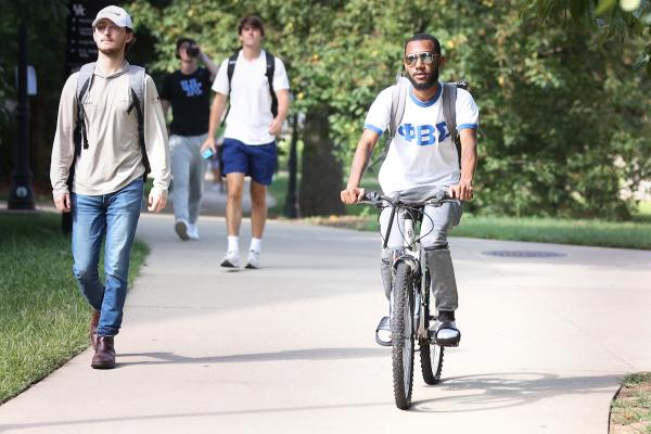 student riding bike on campus