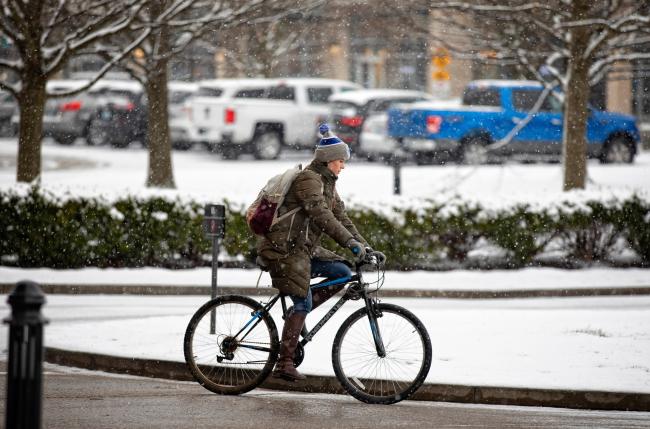 student riding bike in snow