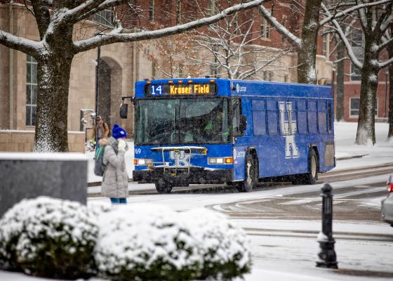 UK Bus and UK students walking in the snow