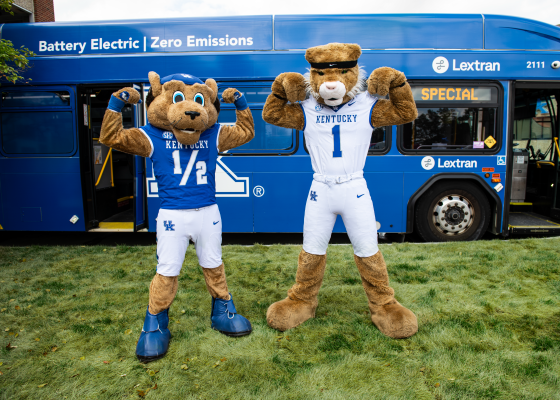 Scratch & Wildcat posed at the side of a bus