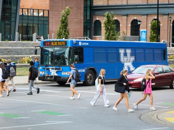 Big Blue bus marked route 14, parked at a bus stop in front of the student center.