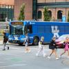Big Blue bus marked route 14, parked at a bus stop in front of the student center.